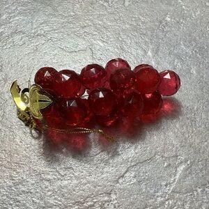 Plastic or acrylic grapes.